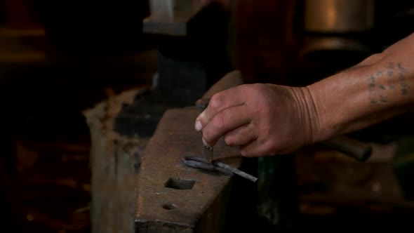 Hands of Blacksmith Beating Metal with a Hammer