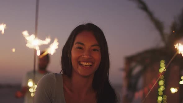 Caucasian woman playing with fire on the beach