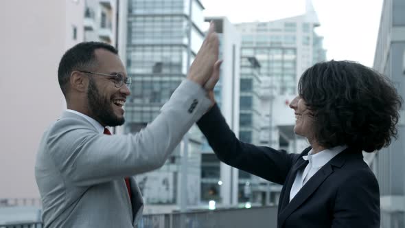 Cheerful Colleagues Giving High Five on Street.