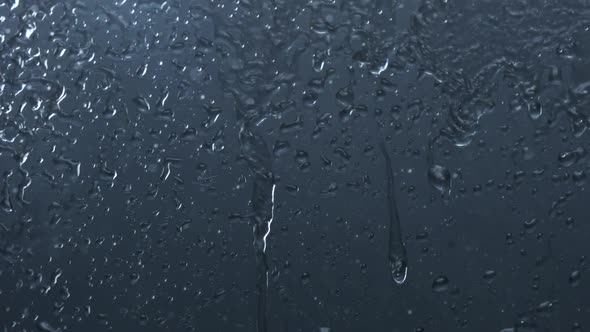 Water dripping down on window glass, Slow Motion