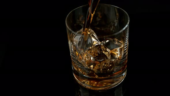 Super Slow Motion Shot of Pouring Whiskey Into Glass with Ice Cubes at 1000Fps with Camera Movement