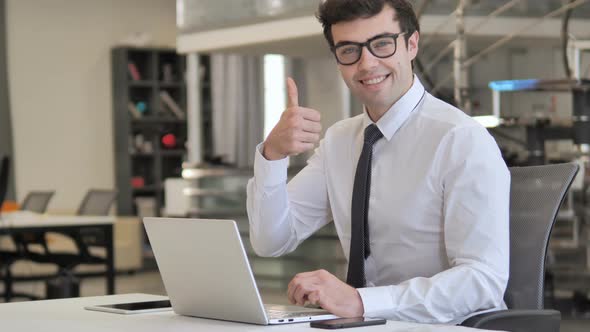 Thumbs Up by Businessman Looking at Camera