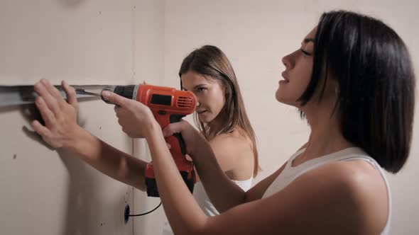 Young Women Make Repairs in the Apartment