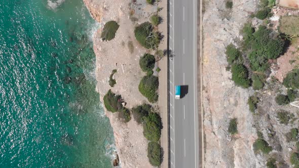 Car road along seashore fortified with hills