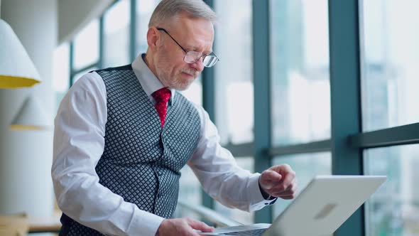 Businessman Using Laptop. Handsome businessman working on laptop in cafe