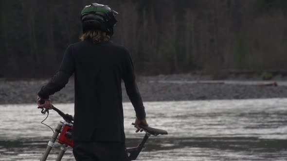 A young man mountain biking in a forest on a mountain.