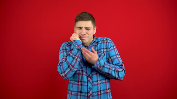 The Young Man Has a Toothache and Touches His Cheek with His Hand