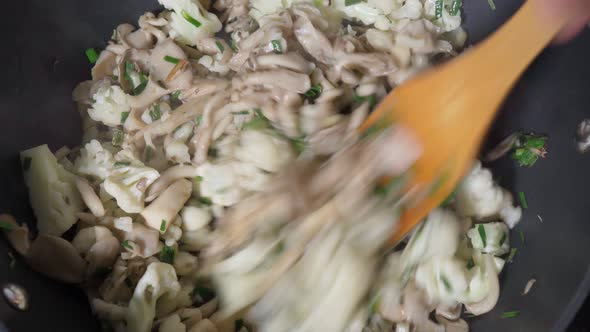 Cooking Fried Mushrooms and Other Vegetables Onions and Parsley are Fried in a Frying Pan