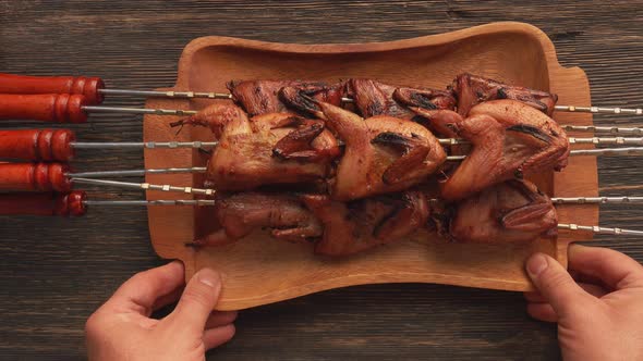 Top View of a Plate Full of Grilled Quails on the Skewers Placed on the Table