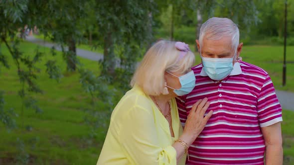 Senior Family Grandmother and Grandfather Wearing Medical Protective Mask in Park During Coronavirus