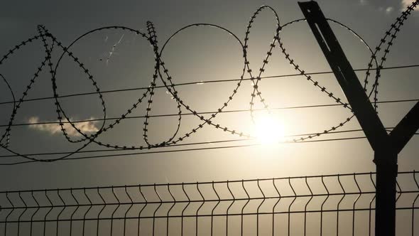 Barbed Wire on the Fence Against the Sunset