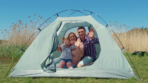 Family with a Little Girl in Nature Resting in a Tourist Tent