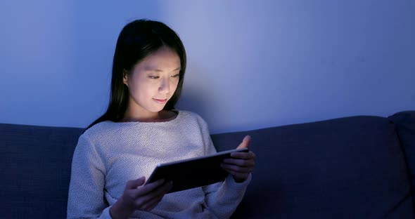 Woman Reading on Tablet Computer at Night