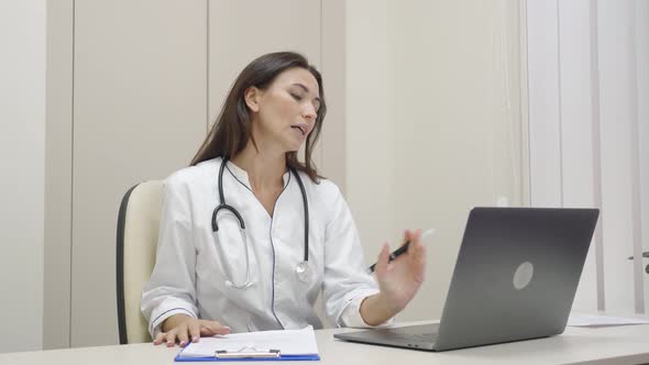 Female Medical Assistant Online Video Calling Distant Patient on Laptop