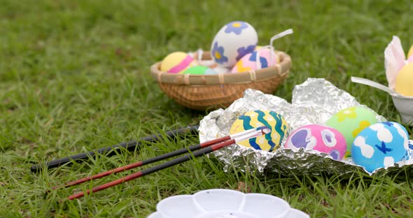 Painting Easter egg on green lawn for holiday