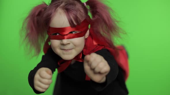 Funny Child Girl in Costume and Mask Plays Super Hero. National Superhero Day