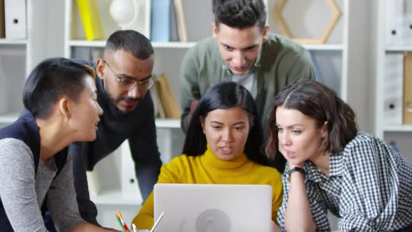 Young Woman Sharing Creative Project with Colleagues