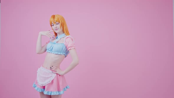 Young Female Model Posing and Touching Her Hip Wears Crop Top and Short Pink Skirt with Apron