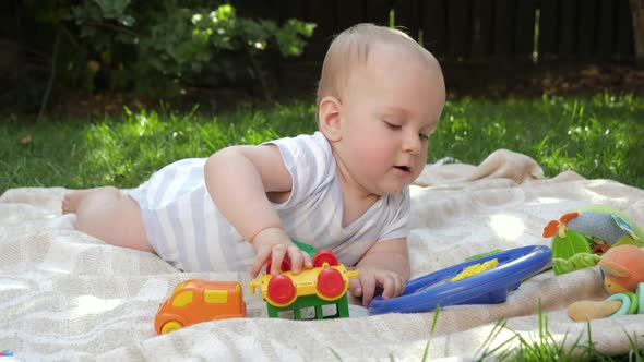 Portrait of Smiling Baby Boy Playing Toys on Picnic at Park