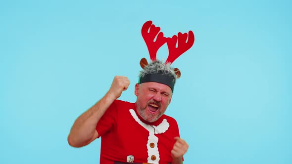 Adult Adult Man in Tshirt Santa Christmas Hat Jumps From Below Dancing Fooling Around Having Fun