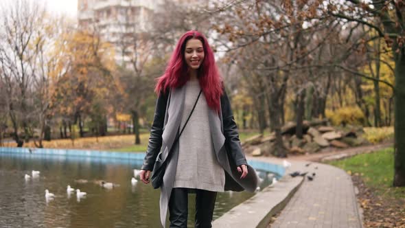 Attractive Woman with Red Hair Walking Around a Park with Artificial Lake