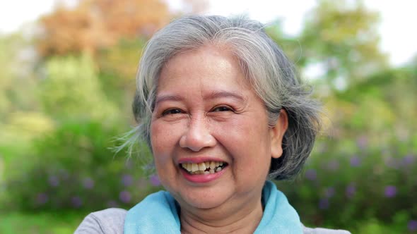 Asian elderly woman exercise in the park in the morning She smiled happily.