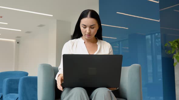 Confident and Cheerful Caucasian Brunette Woman Opening and Typing on a Laptop