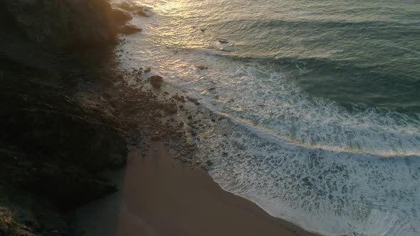 Aerial of four by four vehicle along ocean cliffs at sunset
