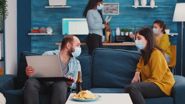 Group of Friends with Face Masks Planning Project Using Laptop