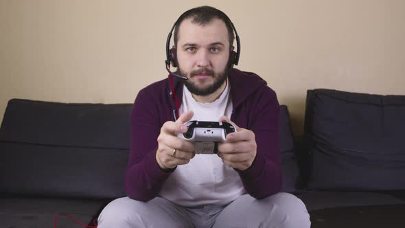 Young Handsome Male Gamer with Headset Play Online Video Game Holding Joystick