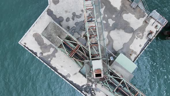 Close-up view of an old deserted coal loading wharf and platform surrounded by the ocean. View from