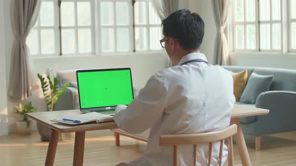 Man Doctor Video Call On Laptop Computer With Green Screen And Talking To Patient Online