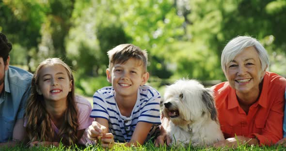 Multi-generation family relaxing with their dog in the park