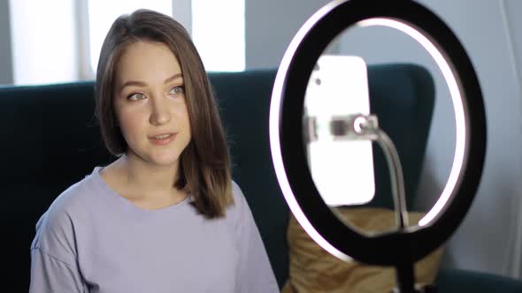 Portrait of Woman Blogger Is Shooting a Video on Smartphone Using Ring Lamp