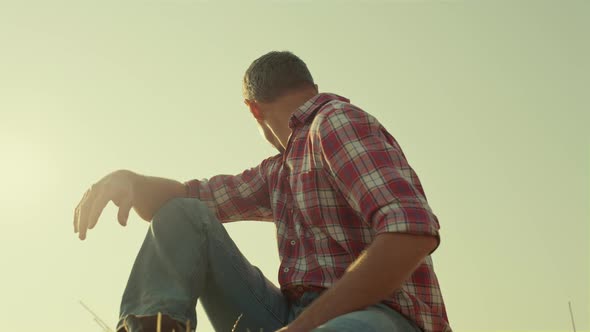 Agribusiness Worker Resting Field in Sunlight