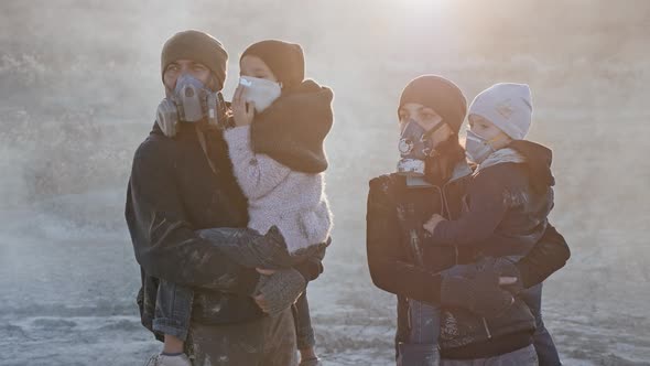 Portrait of Survivor Family in Gas Mask Standing in Clouds of Toxic Smoke and Cinder