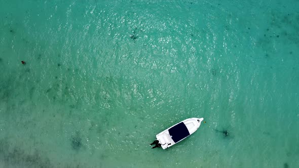 Aerial birds eye shot of anchored luxus speedboat on crystal clear ocean surface