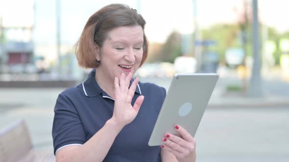 Video Call on Tablet By Old Woman Outdoor