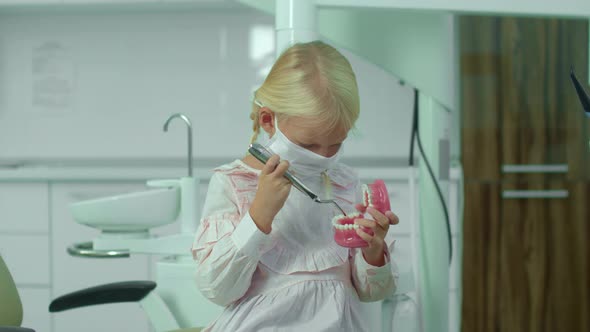 Girl Holds Nippers and Medical Jawbone in Her Hands.