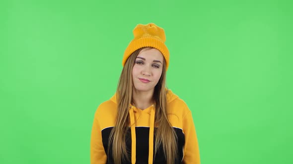 Portrait of Modern Girl in Yellow Hat Is Waiting and Yawning with Boredom. Green Screen
