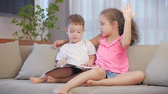 Cute Children,sister with a Younger Brother, Looking at a Book Magazine Textbook Dictionary Tablet