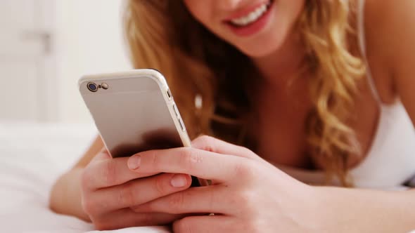 Woman using mobile phone in bedroom