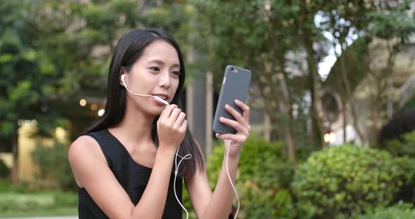 Woman listen to music on cellphone with earphone
