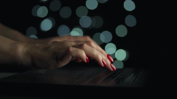 Female Hands is Typing on a Laptop at Night