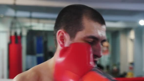 Box Training - a Man with Mouth Guard Getting Hit - the Guard Flies Out of Mouth