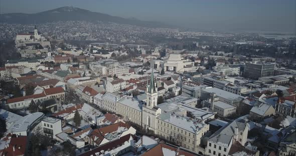 Wide aerial shot of Nitra town with Castle and mountains in background, Winter, Slovakia