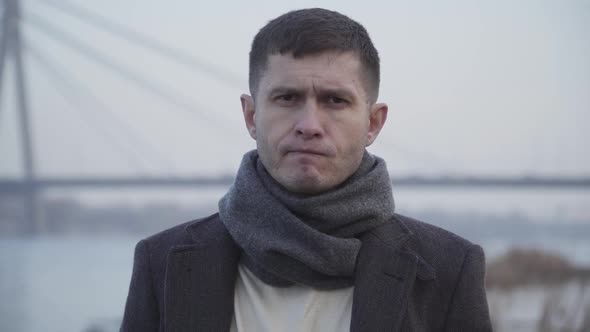 Close-up Face of Sad Caucasian Brunette Man with Brown Eyes Looking at Camera and Sighing. Portrait