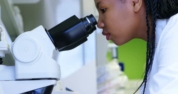 Scientist looking through microscope 