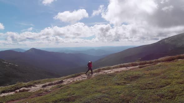 Aerial View of a Traveler with a Backpack Climbing Along Mountain Slope