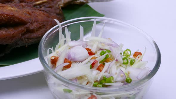 Close-up Footage of Deep Fried Sea Bass Served With Spicy Sour Mango Salad